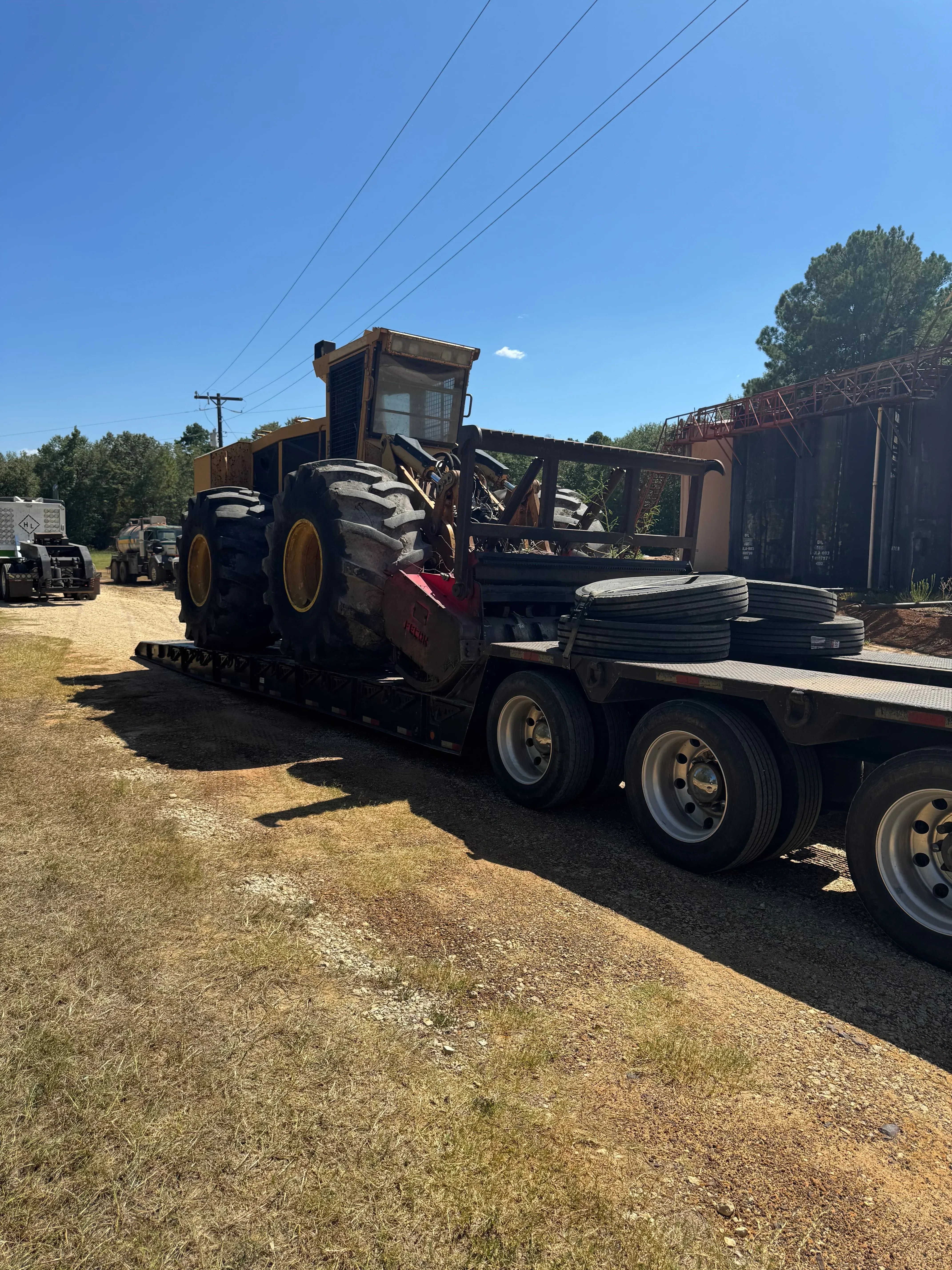 Heavy loader and dump truck on cleared land during forestry operation